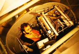 Eager grad student in prime-focus cage of Shane telescope